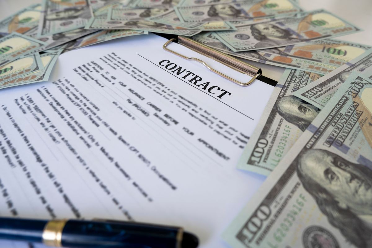 Sign contract for more money, US Dollar banknotes money on printed contract paper and pen to sign